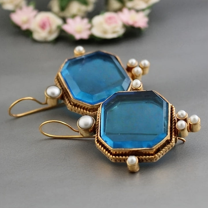 Pendientes colgantes vintage con acentos de cristal azul y flor de lis