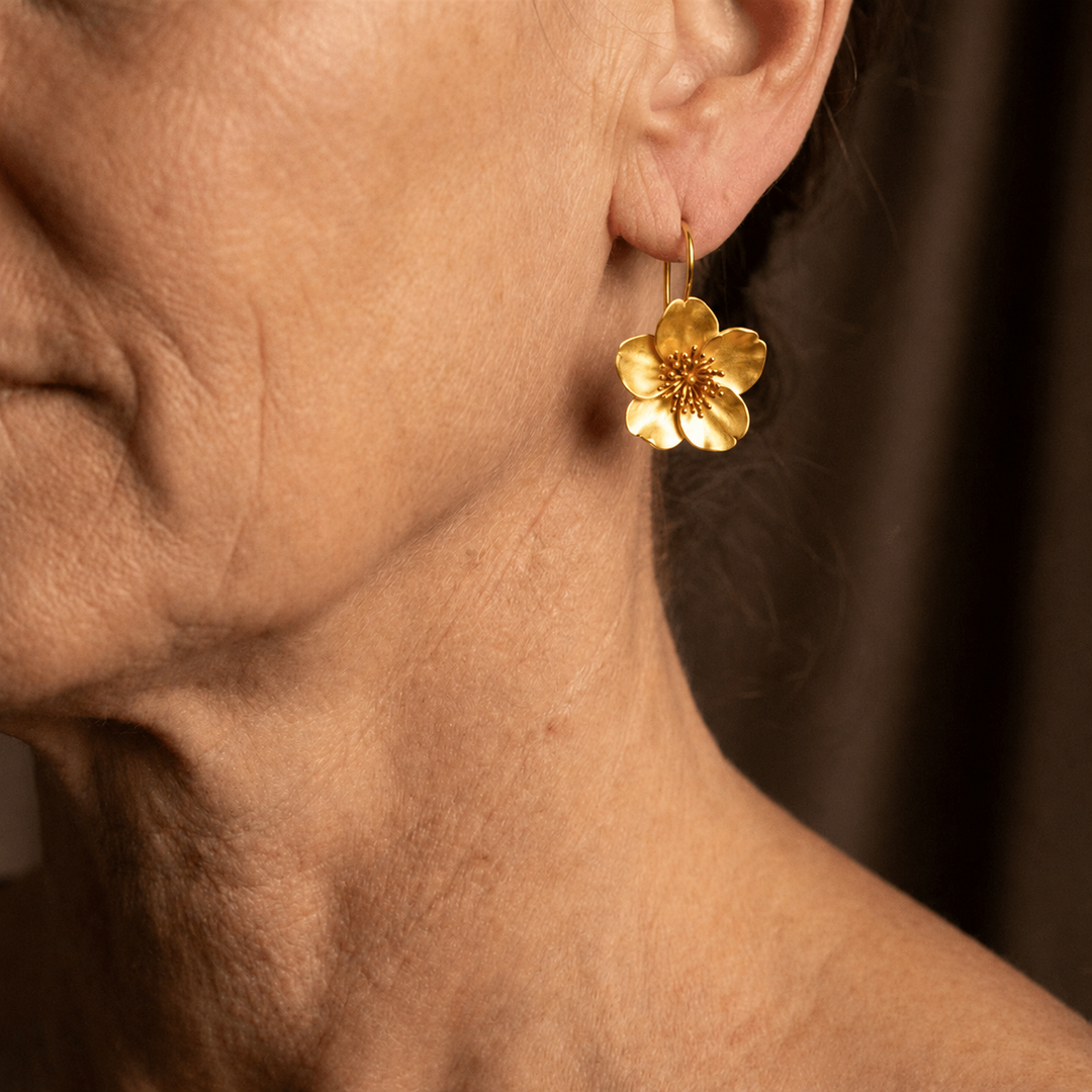 Pendientes clásicos de flor dorada con detalle central dorado