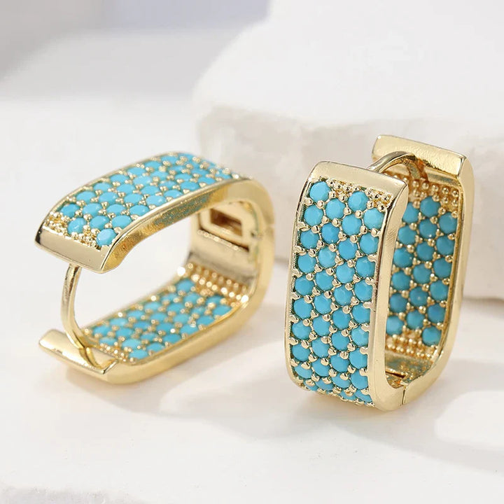 Pendientes huggie dorados con pavé de turquesa