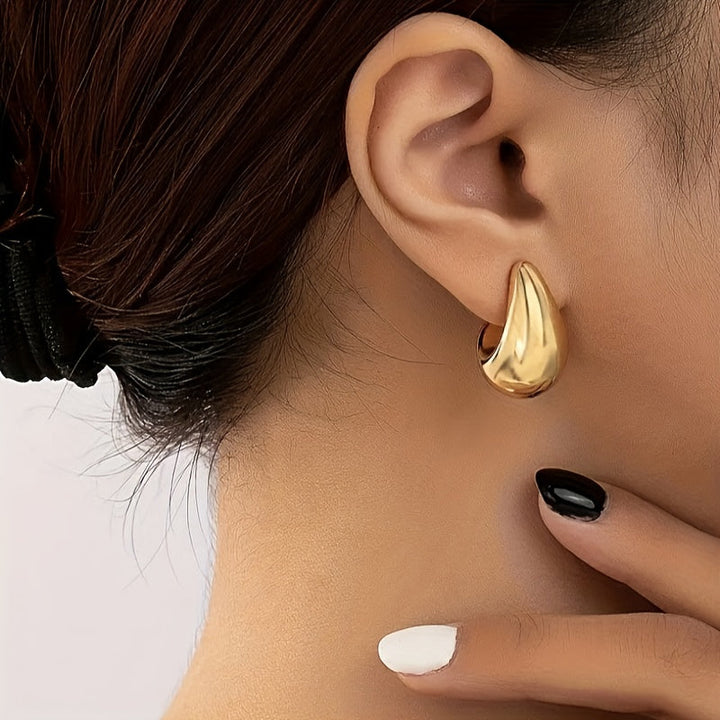 Pendientes minimalistas dorados en forma de C escultórica